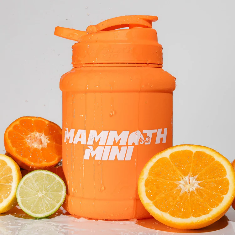 Mammoth Mug Mini 1.5L with redesigned lid, engraved scale, and leak-proof cap, surrounded by sliced oranges and limes, ideal for hydration and easy fruit infusion.